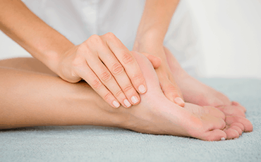 Refleksologia stóp ukazana poprzez masaż pięty lewej stopy